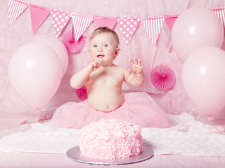 Portrait of cute adorable Caucasian baby girl with blue eyes in pink tutu skirt celebrating her...