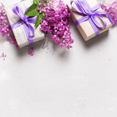 Border from wrapped  gift boxes with presents  and lilac flowers