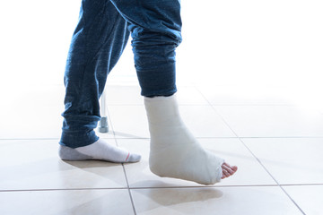 Young man with a broken ankle and a leg cast