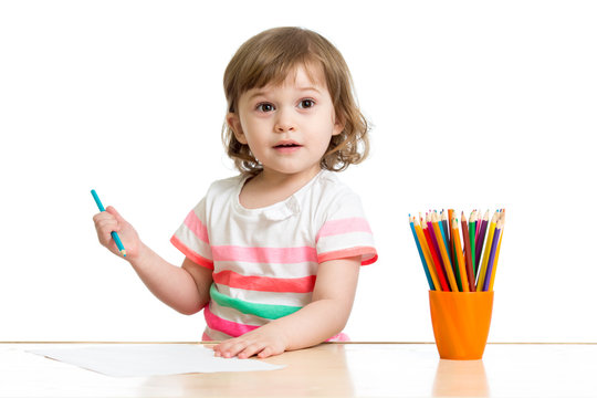 Happy kid little girl drawing with pencils in preschool