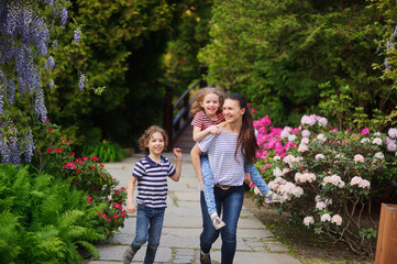 Fototapeta premium Mother with the children in a lush park