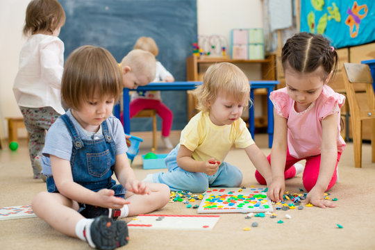 kids or children playing mosaic game in kindergarten room