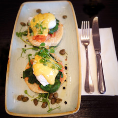 Eggs Benedict with salmon (also known as Eggs Atlantic, Eggs Hemingway, Eggs Copenhagen, Eggs Royale and Eggs Montreal) topped with microgreens, hollandaise sauce and capers.