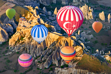 Fototapeta premium Hot air balloons over mountain landscape in Cappadocia, Turkey