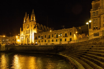 Fototapeta na wymiar Church of Our Lady and Mount Carmela and Balluta Bay in San Juliens, Malta.