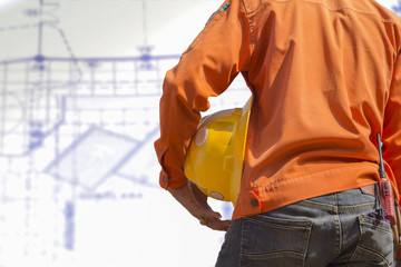 engineer holding yellow helmet for workers security on backgroun