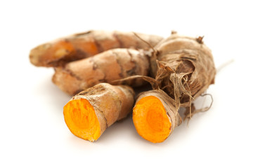 Collection of whole and sliced fresh Organic Long Turmeric or Haldi (Curcuma longa) isolated on white background.