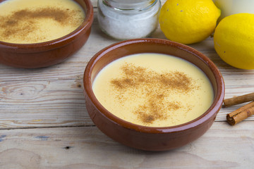 Traditional creme brulee on ceramic dish on wooden table