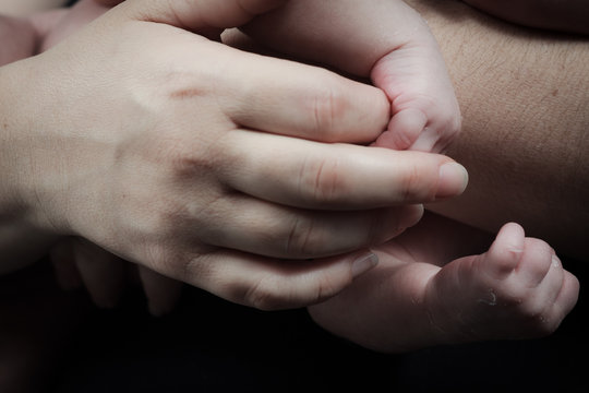 Mother with her newborn baby care hands