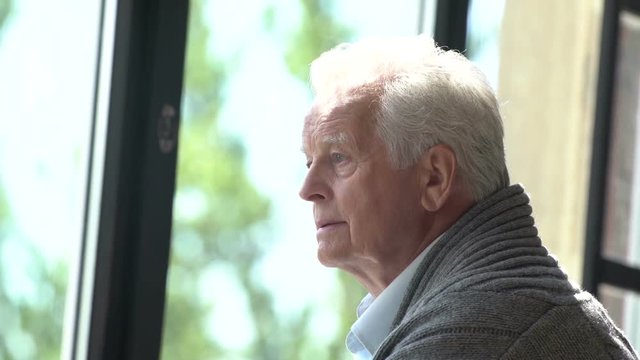 elderly caucasian man look at window, lost in thought