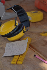 Measuring tools on workbench with earmuffs