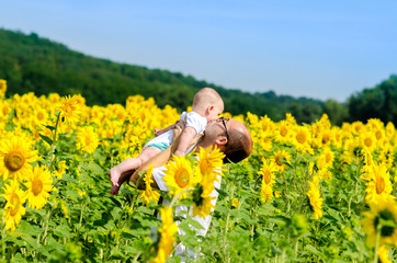 Fototapeta premium Father with son on the sunflower field