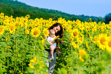 Fototapeta premium Mother with son on the sunflower field.