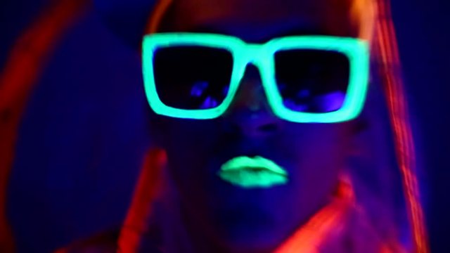 Man is dancing in neon clothes close up