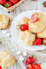 
dessert with berries , custard eclairs or cakes with cream and red strawberries on a wooden background