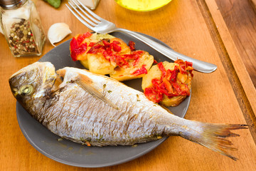 roasted sea bream with potatoes on wooden