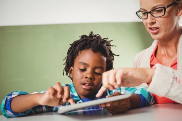 Naklejka premium Teacher and pupil using a tablet