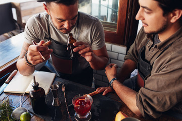 Two bartenders experimenting with creating cocktails