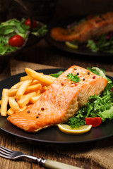 Baked salmon served with french fries.