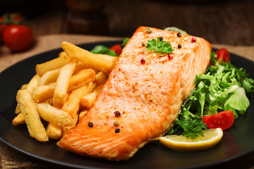 Baked salmon served with french fries.