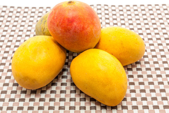 Ripe yellow and red colored mango fruits on mat background