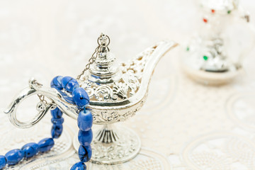 Blue Islamic rosary on Silver Alaadin's lamp .Ramadan Eid background