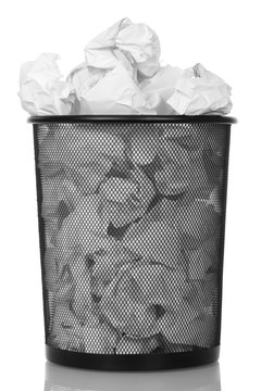 Metal basket with paper waste isolated on white.