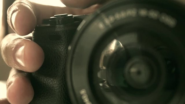 Man grips mirrorless photo camera macro shallow focus video