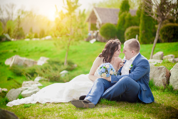 Fototapeta premium Bride and Groom, Kissing at Sunset on grass Romantic Married Couple