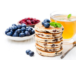Stack  of welsh cakes with blueberry and a cup of green tea