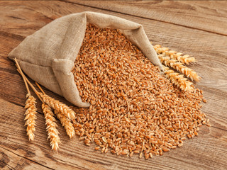 wheat grain in a bag and spikes on the table