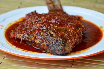 deep fried black mango fish dressing chili sauce on plate
