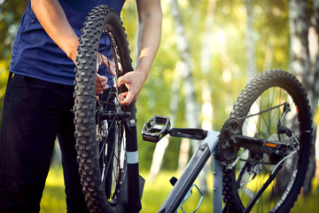 Man repairing a bike in the forest