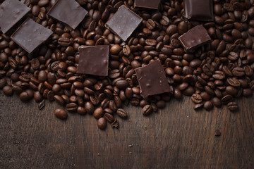 Coffee beans with chocolate on wooden background