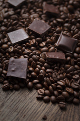Coffee beans with chocolate on wooden background