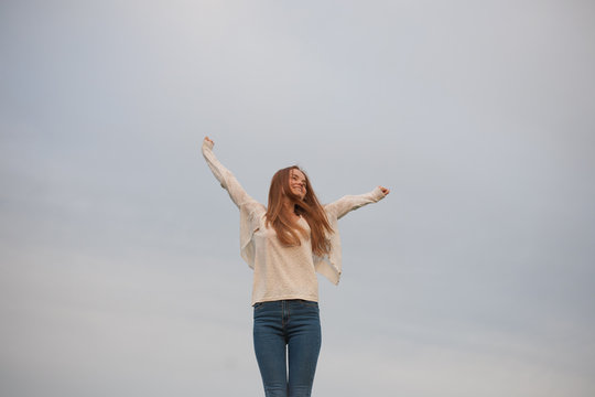 woman with open arms in the sky background at the morning