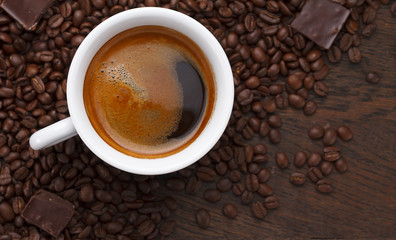 Coffee cup. Coffee beans and chocolate on a wooden table