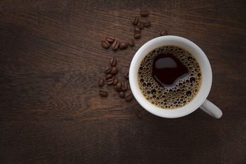 Coffee cup and coffee beans on a wooden table