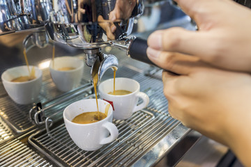 espresso pouring from coffee machine by professional coffee brewing.