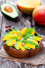 Fresh  vegetarian salad with mango and avocado in the wooden pla © lena_zajchikova