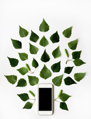 mobile phone and green birch leaves pattern on white background.