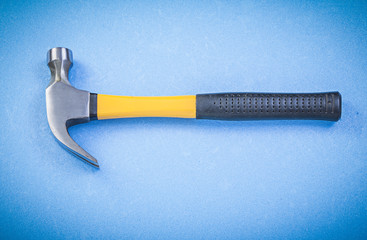 Claw hammer on blue background top view construction concept