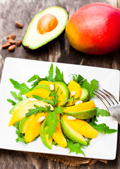Fototapeta na wymiar Fresh vegetarian salad with mango and avocado in white squared