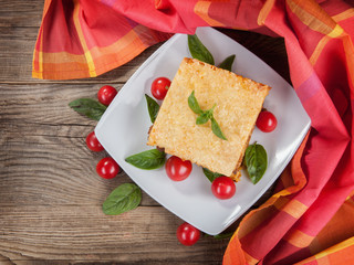 Lasagna and tomatoes napkin on the board