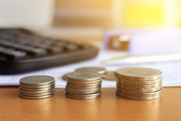 coins tower (Thai money) on wood tableม business and saving money concept, over sunlight  [blur and selective focus background]