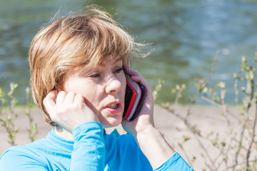 the woman speaks by phone against water