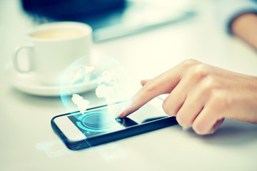 close up of woman hand with smartphone and globe