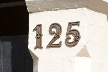 House Number 125 sign on wall