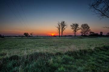 Fototapeta na wymiar Krajobraz wiejski. Wschód słońca nad łąkami