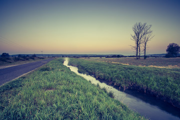Obraz premium Krajobraz wiejski. Wschód słońca nad łąkami
